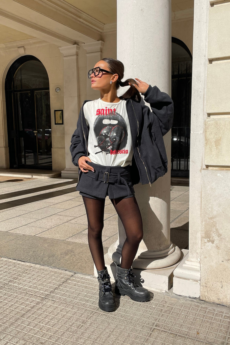Mujer joven posando con Short pollera Circe tiro bajo de paño con cinturón color gris oscuro de DELAOSTIA.
