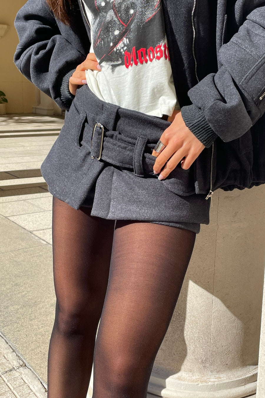 Detalle de Short pollera Circe tiro bajo de paño con cinturón color gris oscuro.