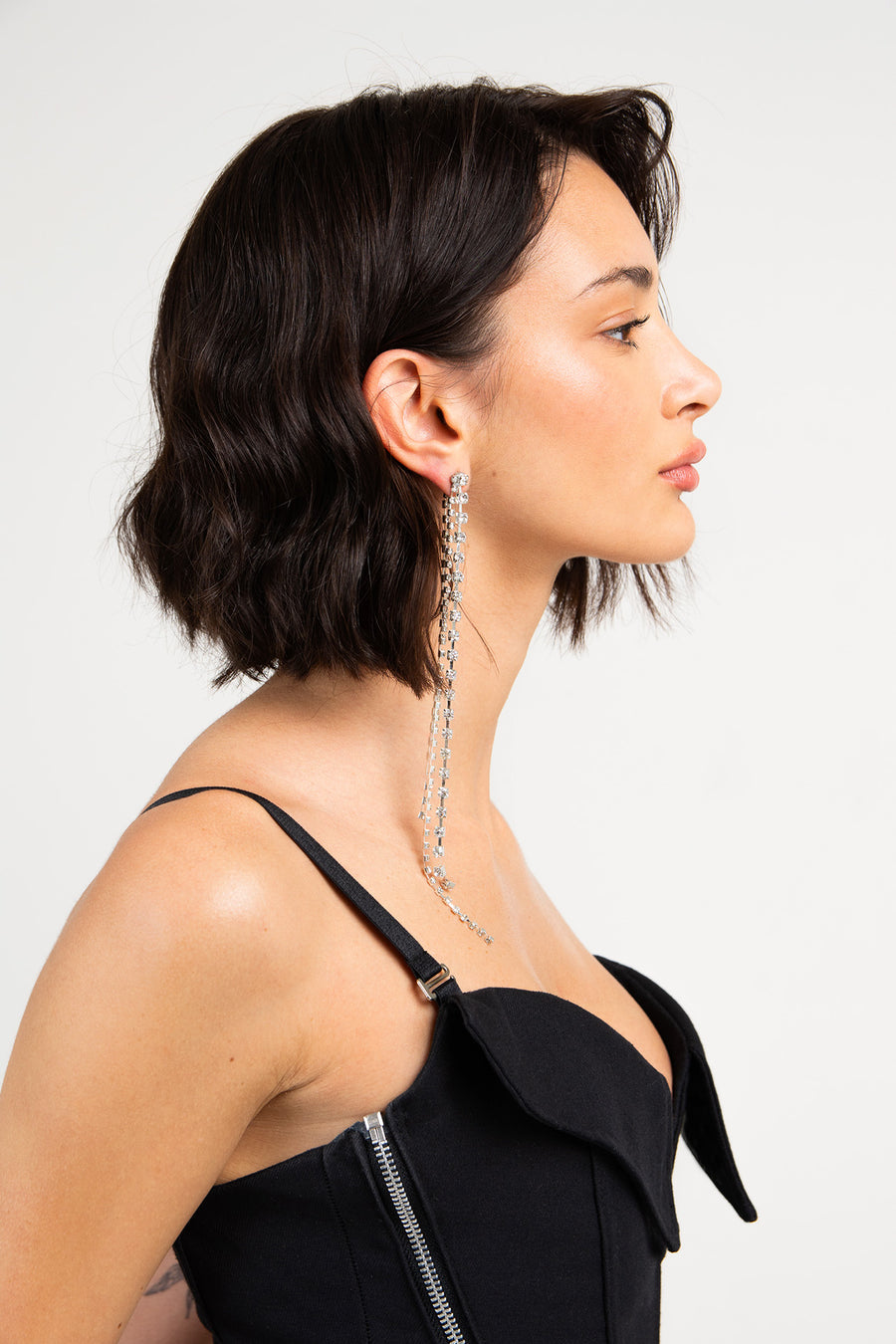 Modelo posando de costado con Aro Belial solitario de strass, largo.