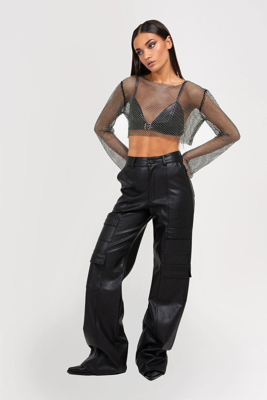 Modelo posando con Pantalón Midnight cargo tiro alto de PU con bolsillos, color negro.