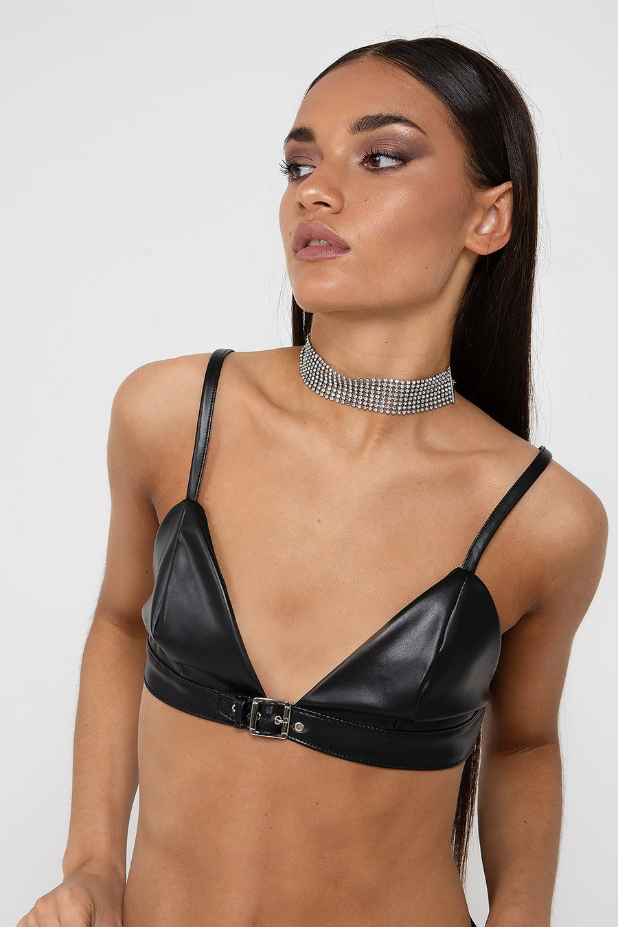 Modelo posando con Corpiño Harriet color negro de PU con un cautivador detalle de hebilla en la parte delantera.