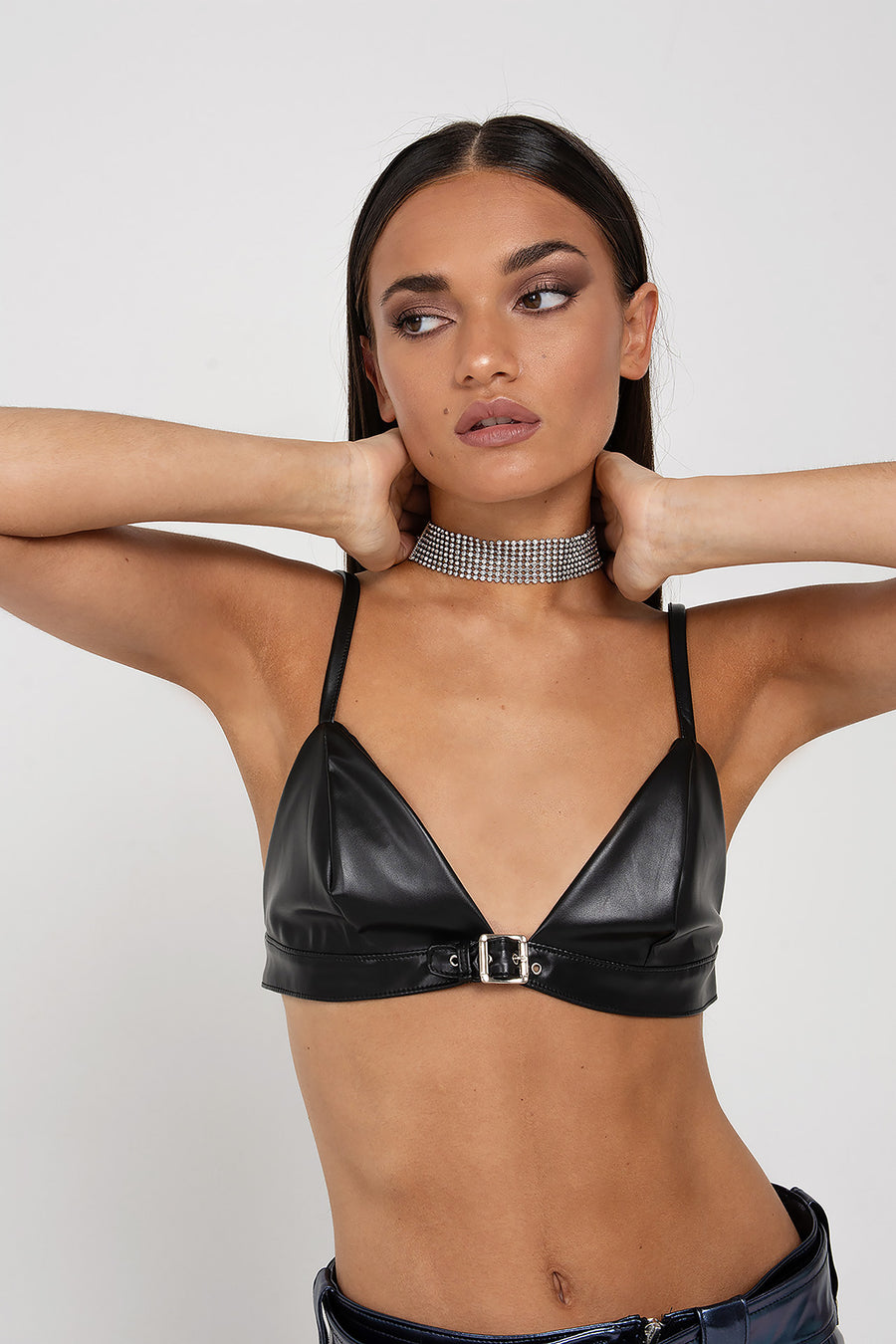 Modelo posando con Corpiño Harriet color negro de PU con un cautivador detalle de hebilla en la parte delantera.