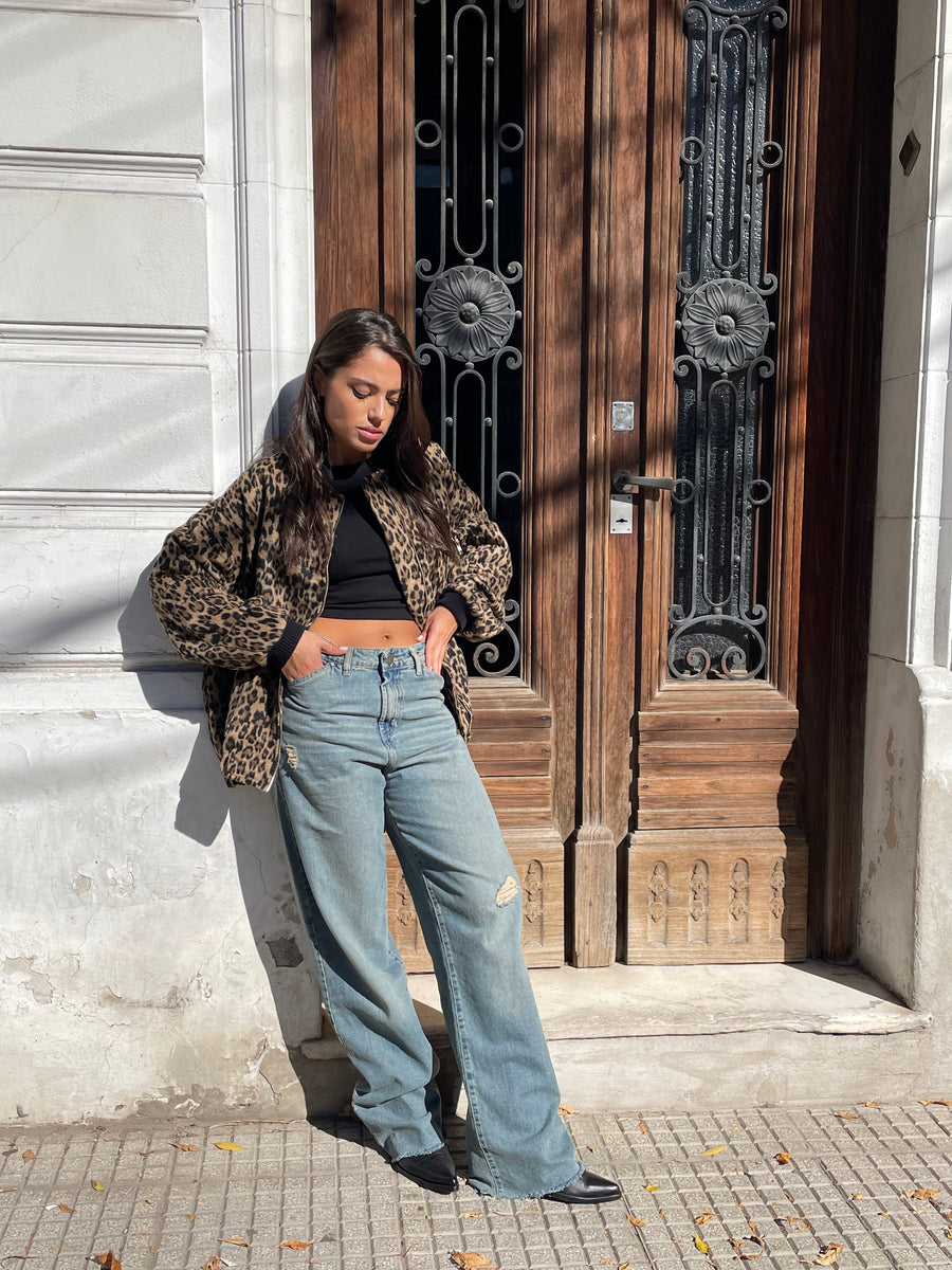 Mujer joven mirando hacia abajo usando campera Bomber Crown con estampado animal print color marrón y negro de Delaostia.