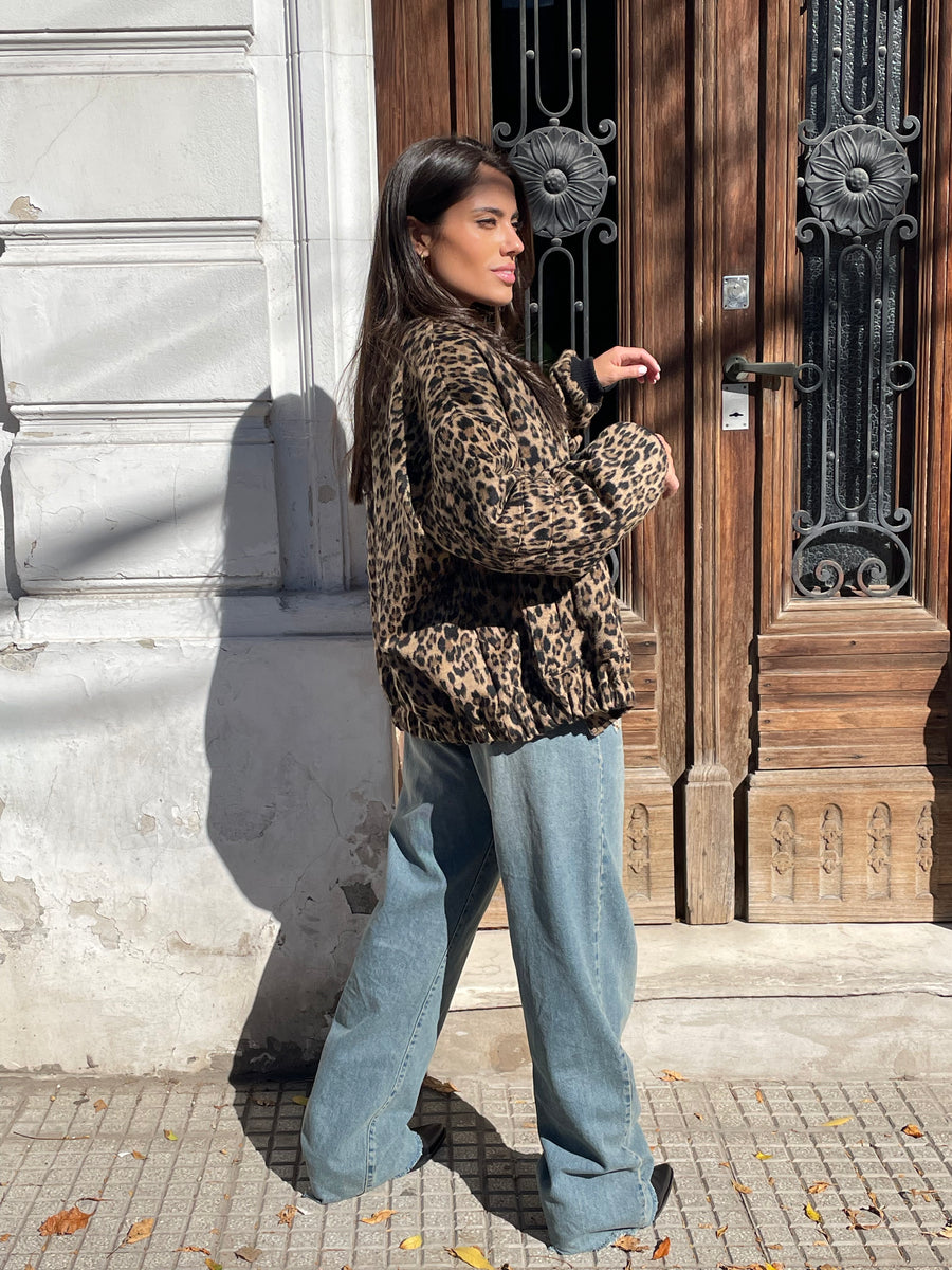 Mujer joven posando de costado usando campera Bomber Crown con estampado animal print color marrón y negro de Delaostia.