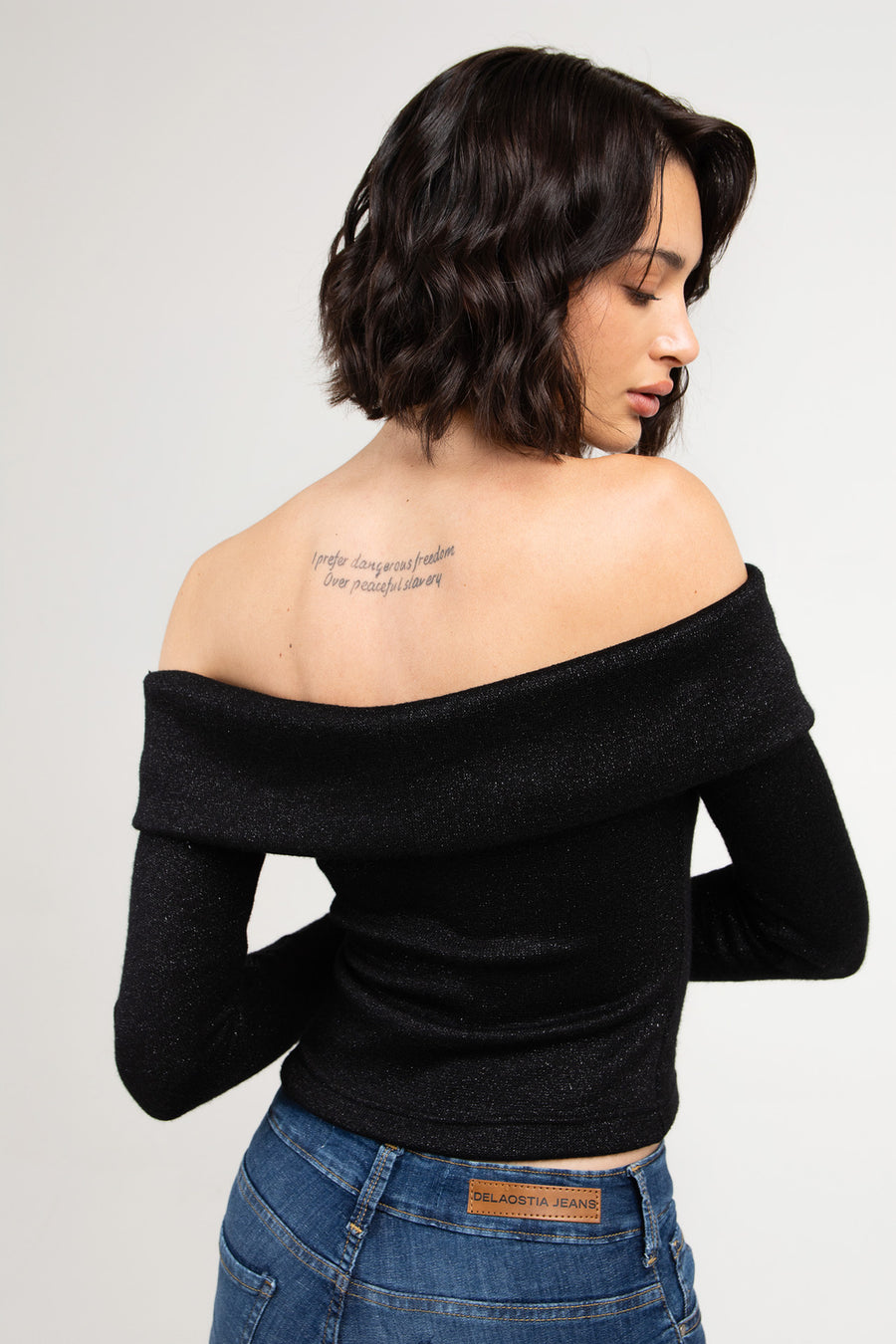 Modelo posando de espaldas con Sweater Ulfred americano de noche, con cuello bote y cierre, color negro.