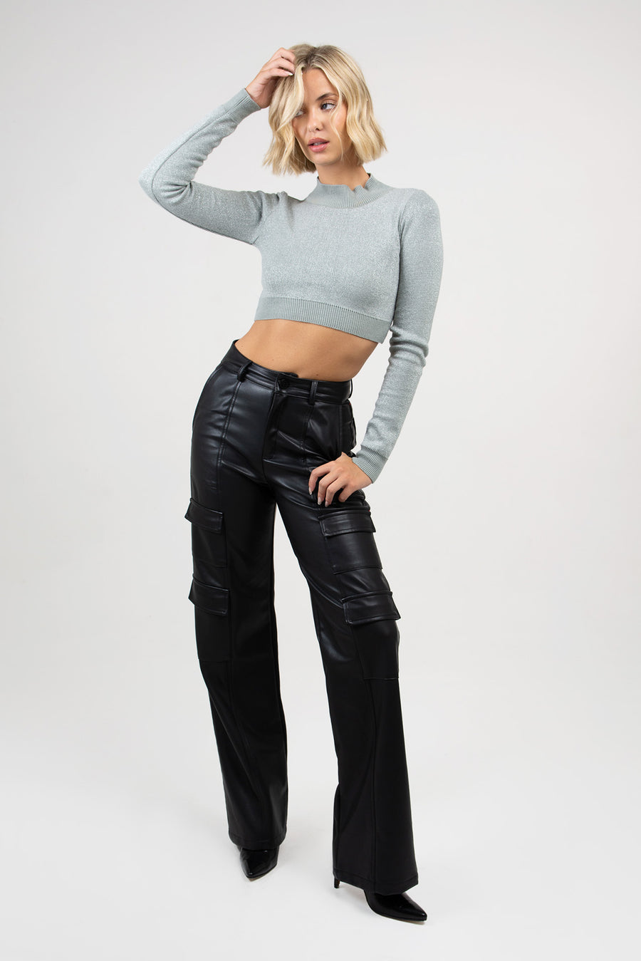 Modelo usando Sweater Zane polera anatómico con brillo color plata y pantalón negro.